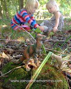 Playing with toy dinosaurs outside.